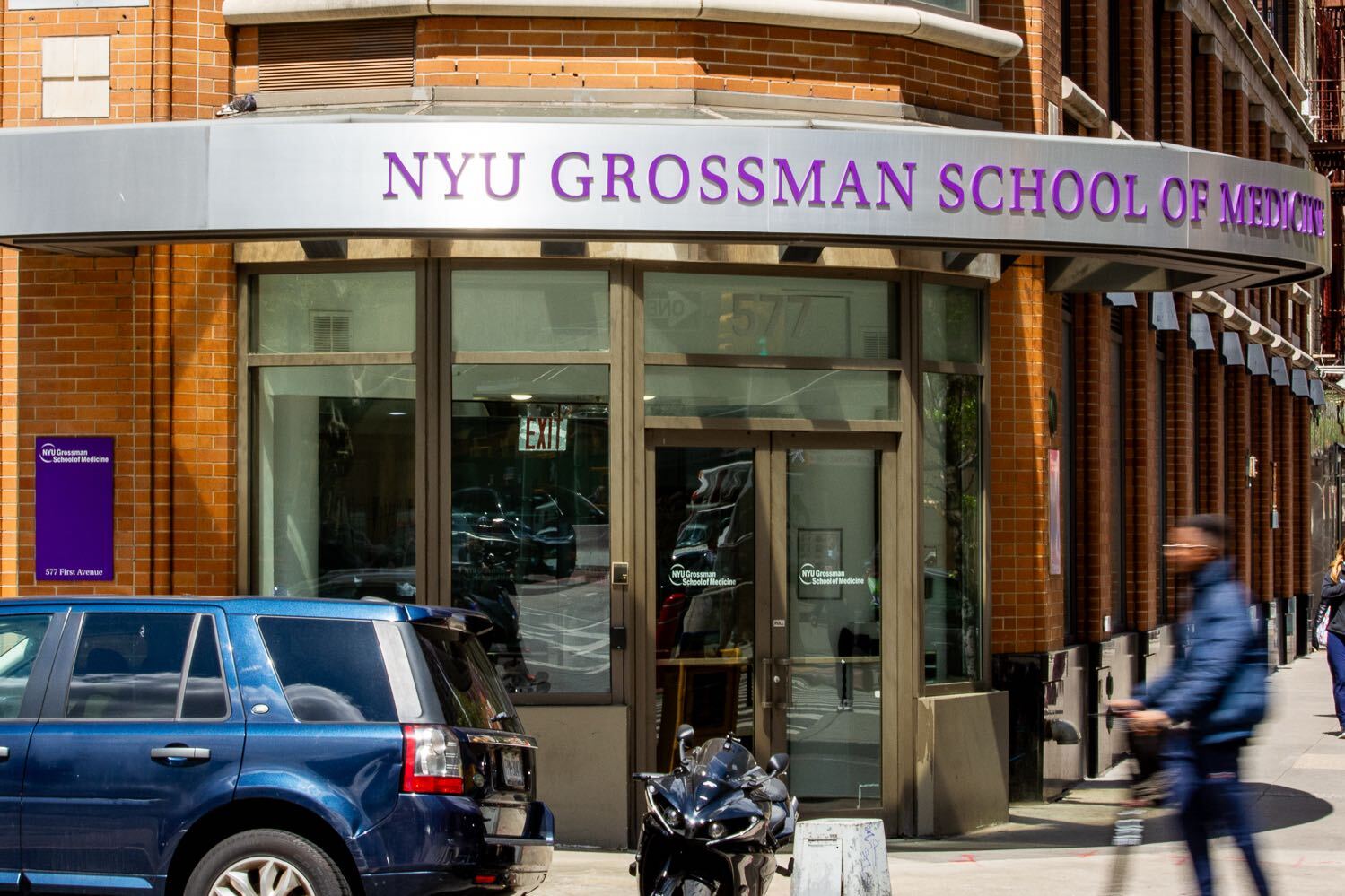 The entrance to a building at a street corner. The signage indicates that the building is N.Y.U.’s Grossman School of Medicine.