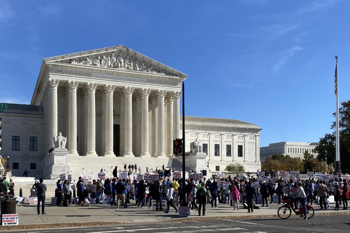 Protesters hold up posters in front of the white marble building of the Supreme Court of the United States in Washington D.C.