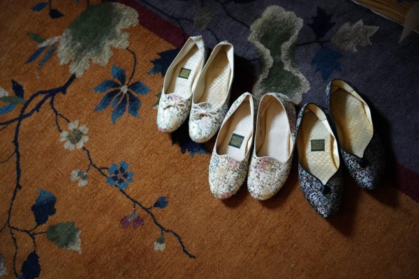 Three pairs of embroidered shoes placed on a carpet.
