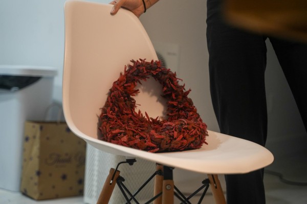 A red bag rests on a white chair.
