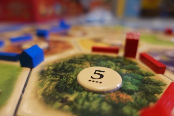A button with the number 5 on it placed on a map of the board game Catan.