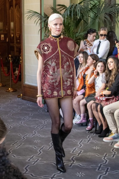 A model wearing a red Devi jacket with golden embroidery.