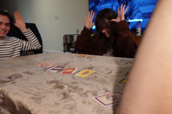 A group of people sitting around a table playing Moose Master.