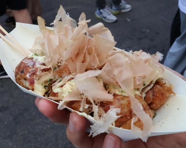 Six pieces of takoyaki placed in a white container.