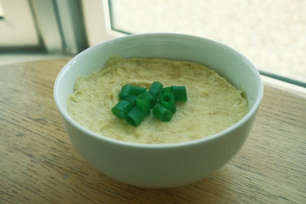 A bowl of Korean steamed eggs with chopped scallions on top.