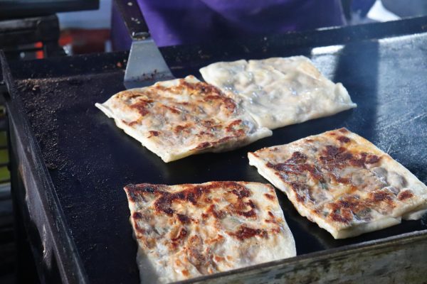 Four palatas are being grilled on an open metal grill.