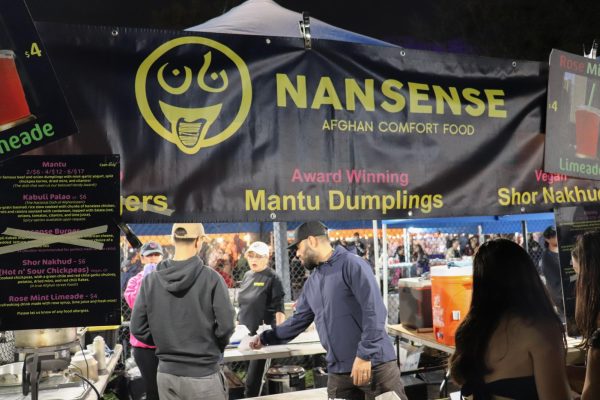 A tent with a black banner that says “Nansense, Afghan comfort food” in yellow texts.