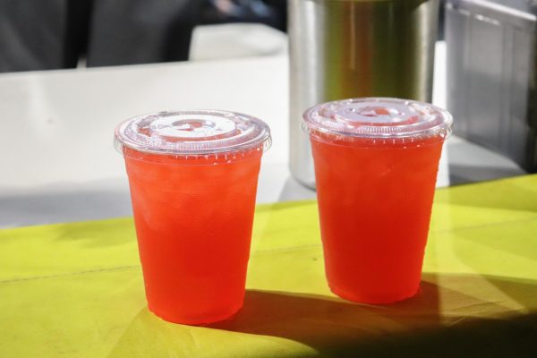 Two cups of light-red beverages placed on a table.