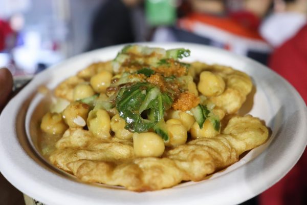 A white plate holding yellow beans and green vegetables on the top.