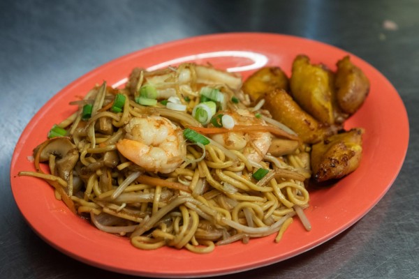A red plate with noodles, shrimp and plantains.