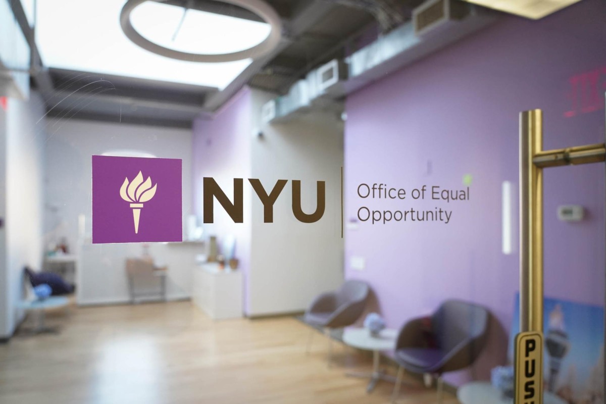A logo of the N.Y.U Office of Equal Opportunity being printed on a glass door. The interior of the office can be seen through the glass door.