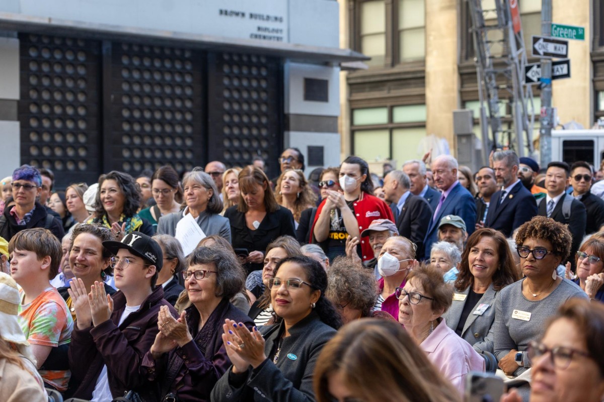 A crowd stands and applauds a speaker during the memorial held for the Triangle Shirtwaist Factory fire.