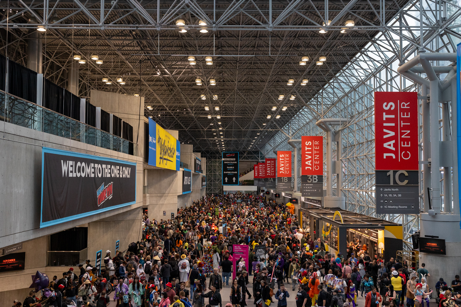 Thousands of Comic Con attendees gather in the Javits Center, many dressed in full costume.