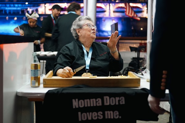 Addolorata Marzovilla, known as Nonna Dora, makes pasta while chatting with people.
