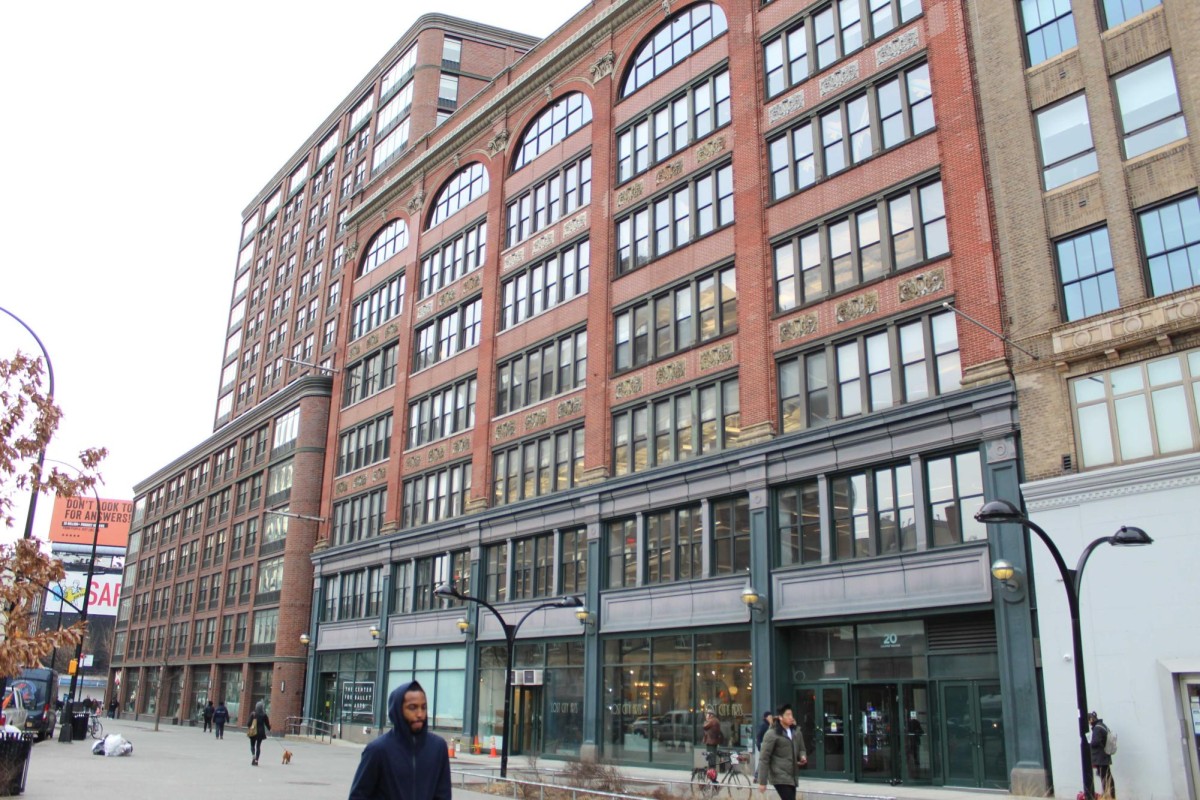 The outside of a building with people walking by on the street.