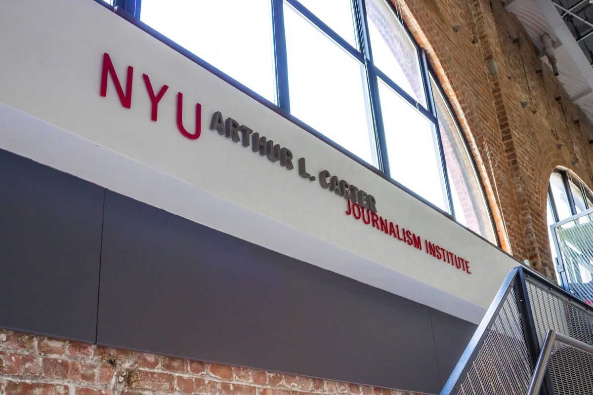 The interior of the seventh floor of the N.Y.U. Arthur L. Carter Journalism Institute with a sign that reads N.Y.U. Arthur L. Carter Journalism Institute.