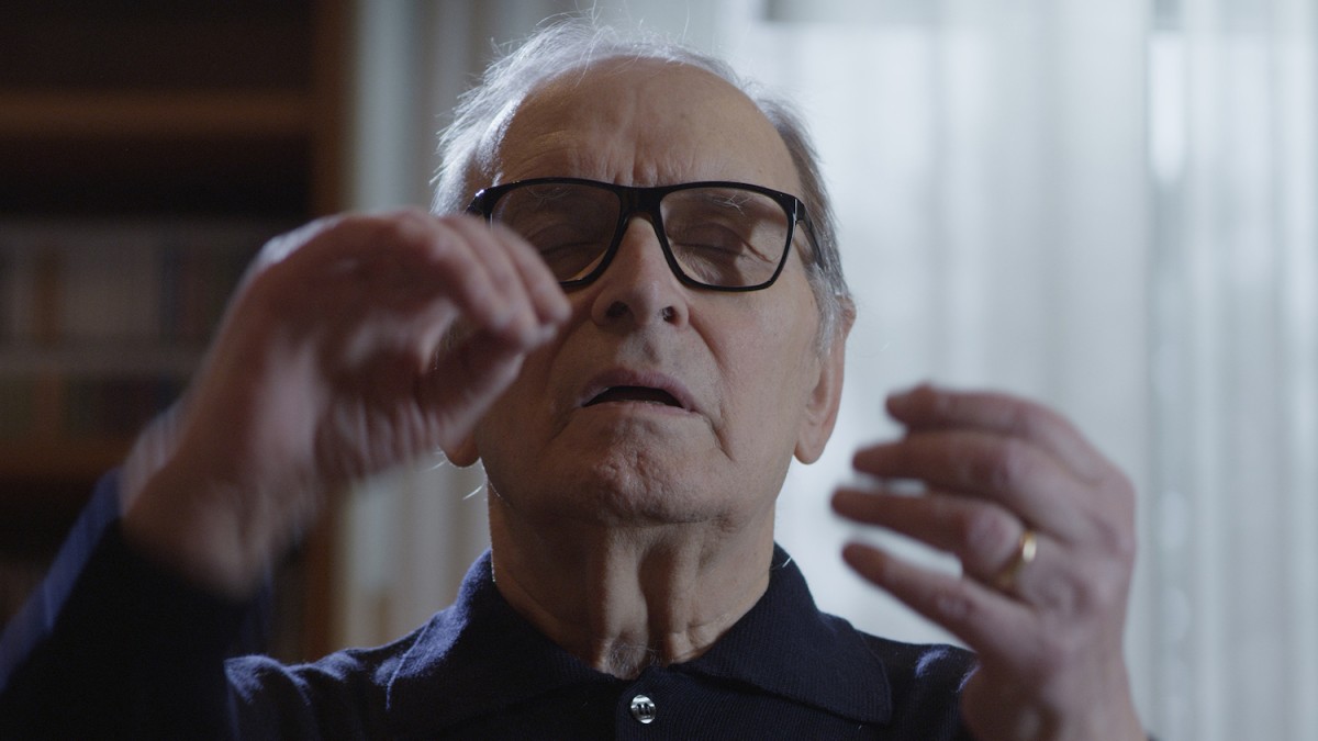Ennio+Morricone+sits+with+his+eyes+closed+and+his+hands+moving+in+front+of+his+face.