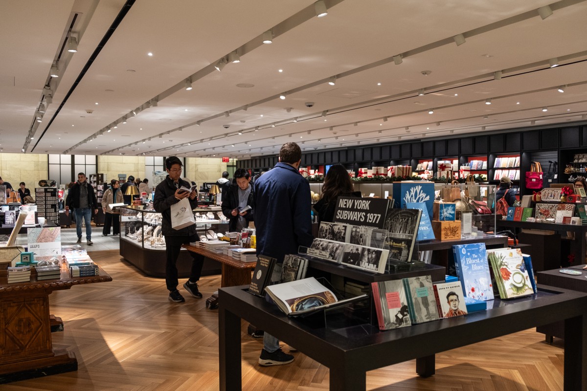 Patrons browse the The New York Public Library gift shop. There are several tables filled with books.