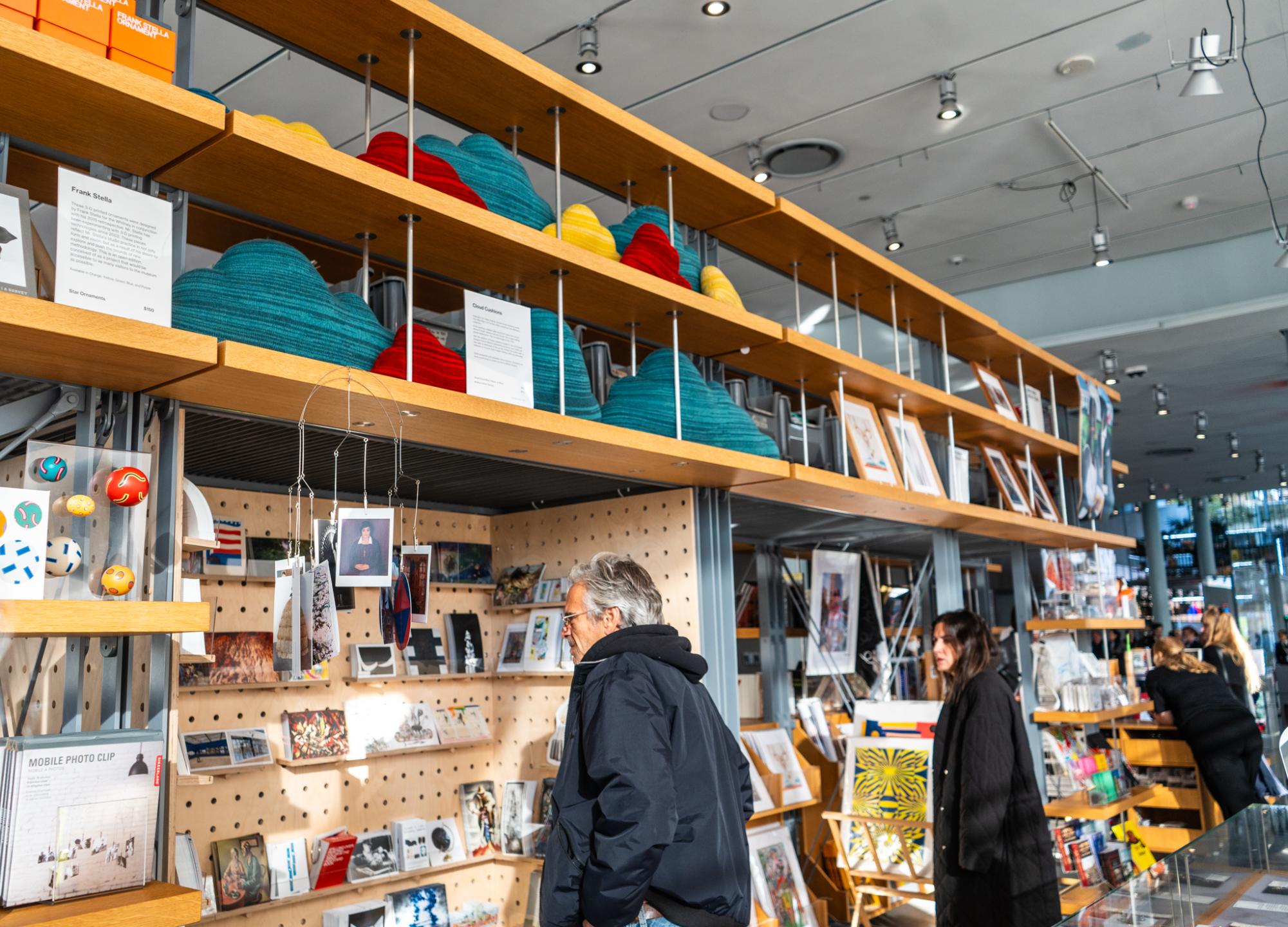 A visitor looking at the photographic art pieces available to purchase in the gift shop of the Whitney Museum of American Art.