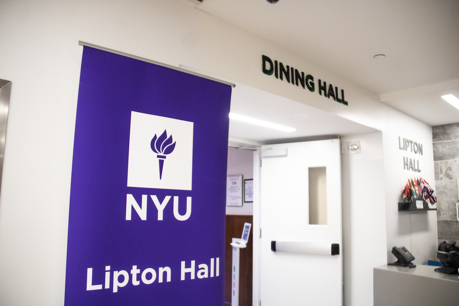 The exterior of Lipton dining hall, with "Dining Hall" at the top of the entrance and a sign on the left reading "N.Y.U. Lipton Hall.”