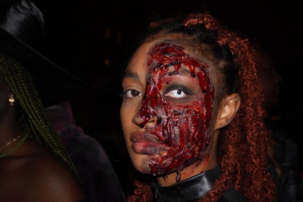 A woman with bloody makeup over half of her face.