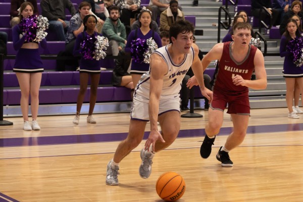 Graduate student and guard Michael Savarino dribbles past an opposition player in N.Y.U. men’s basketball season opener against Manhattanville College.