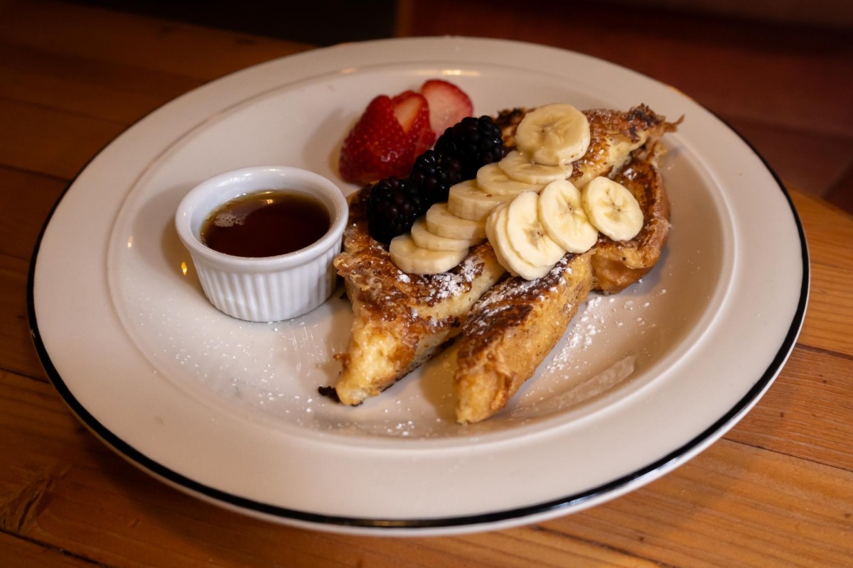 A white dish with Donna’s French toast on a wooden table.