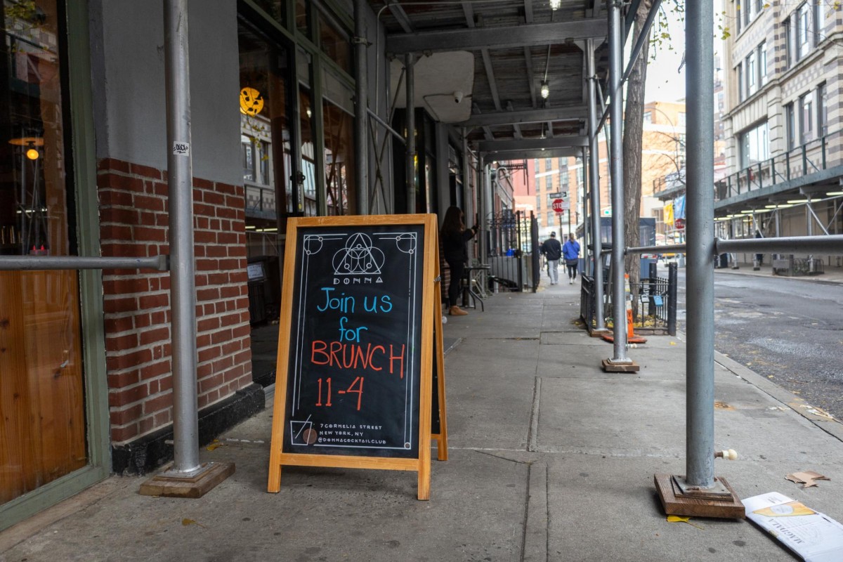 A sign outside Donna’s that reads “Join us for BRUNCH 11-4.”