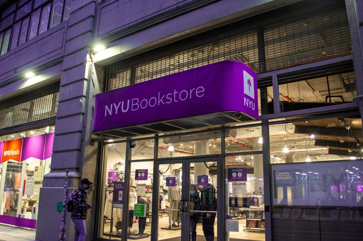 The exterior of the N.Y.U. bookstore. There is a purple sign that reads “N.Y.U. Bookstore” and large glass windows.