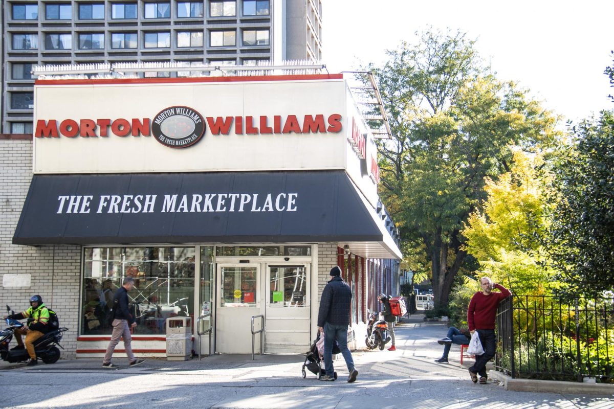 The exterior of the Morton Williams Supermarket, with a prominent red lettering that reads "Morton Williams" at the top of the building and the phrase "The Fresh Marketplace" beneath it.