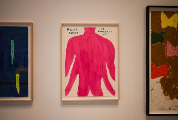 A framed painting of a pink human body with four arms and two legs which reads “FOUR ARMS TO EMBRACE YOU”.