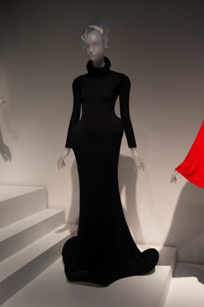 A mannequin wears a turtleneck, full-length black dress.