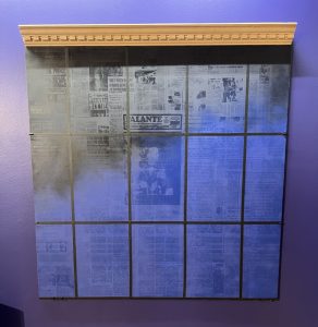 A dark blue window where a collage of newspapers is placed in the background.