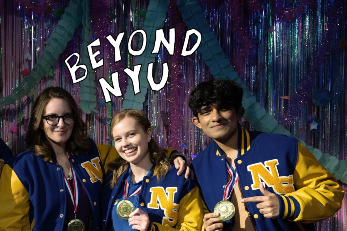 (Left to Right) Tina Fey, Angourie Rice and Mahi Alam wearing their blue and yellow jackets with “NS” written on them while holding gold medals and smiling with their arms around one another.