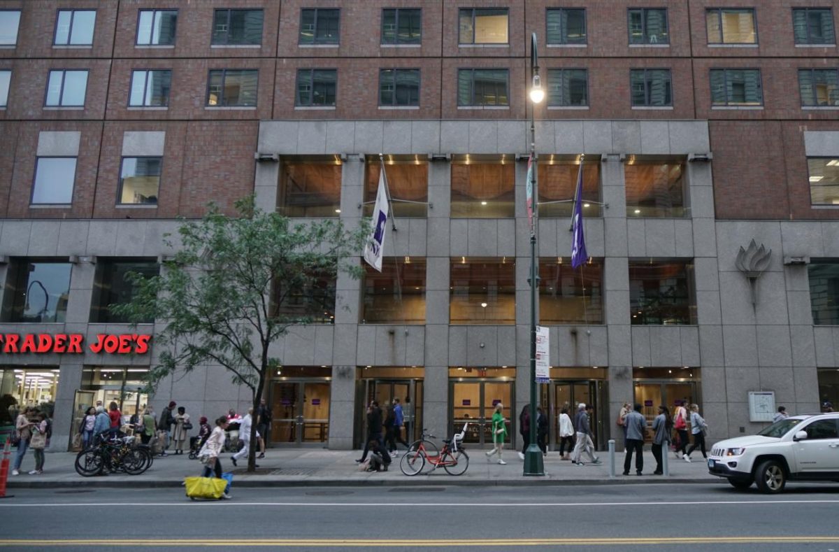 A building facade of N.Y.U. Palladium Residence Hall. Next to it is a Trader Joes grocery store.