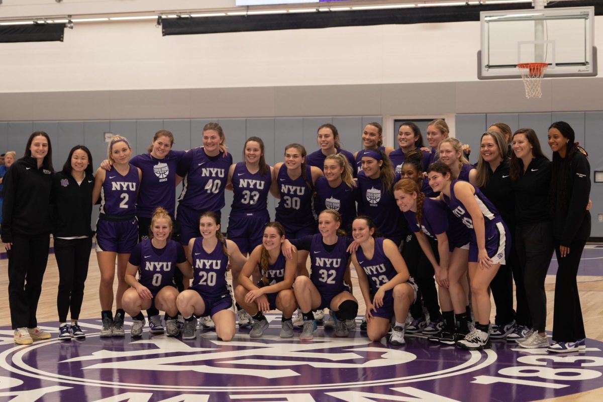 N.Y.U. women’s basketball team poses for a photo wearing purple N.Y.U. jerseys.