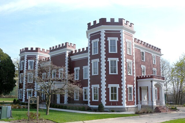 A large brown building with castle-like turrets and rows of windows.