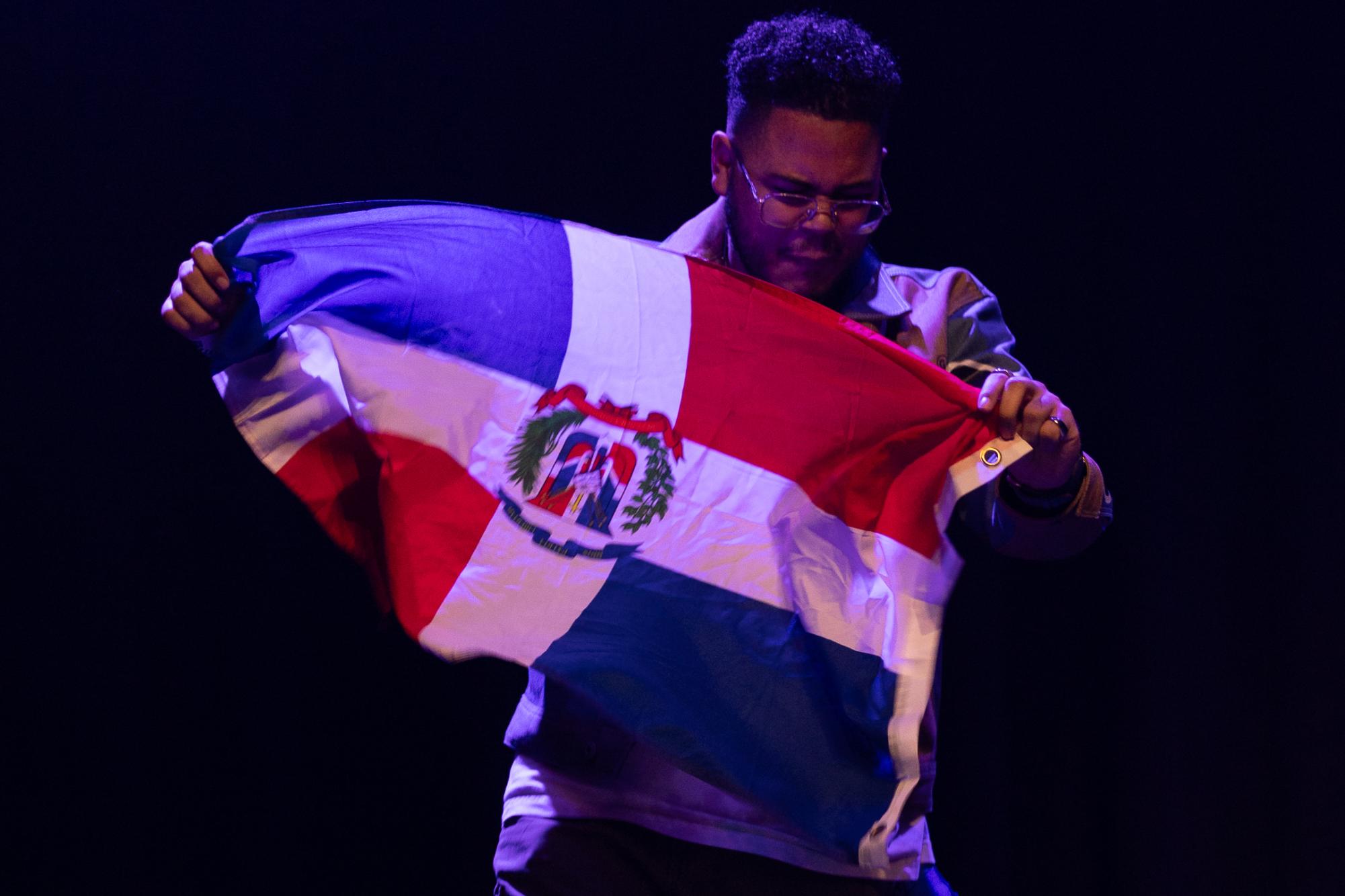 A man holds a flag of the Dominican Republic.