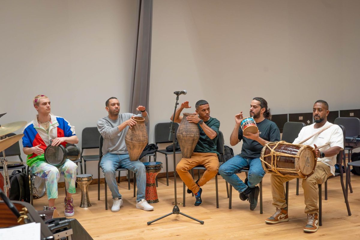 Five+musicians+sitting+and+holding+a+goblet+drum%2C+two+jahlas%2C+a+mirwas+and+a+tabla.