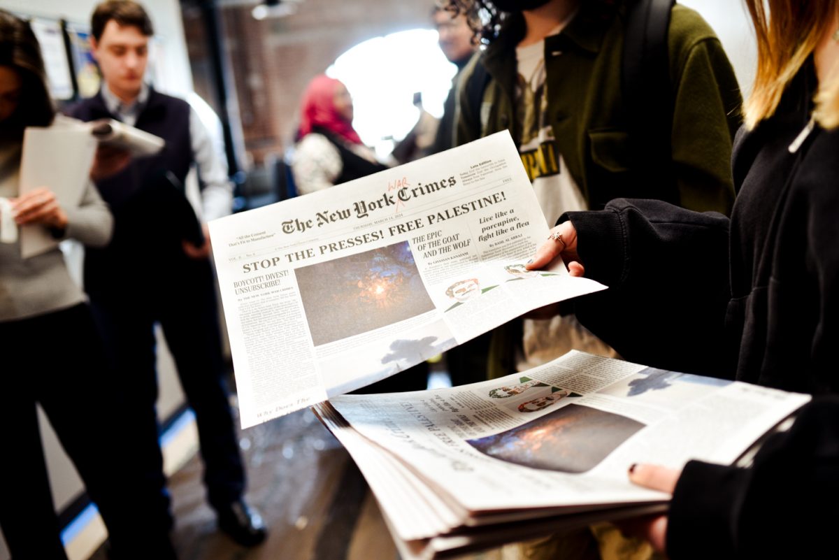 A protester holds a mock newspaper called “The New York Crimes” with the headline “STOP THE PRESSES! FREE PALESTINE!”