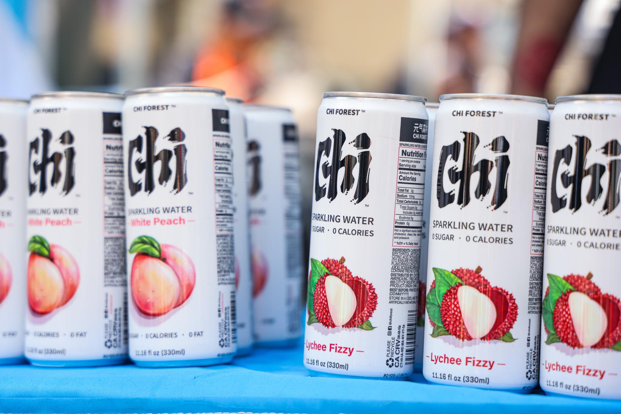 White sparkling water cans displaying various flavors labeled “CHI.”