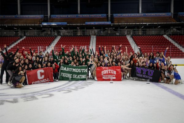 Four figure skating teams holding banners for their respective schools. From left to right the banners read "CORNELL," "DARTMOUTH FIGURE SKATING," "BOSTON UNIVERSITY FIGURE SKATING" and "NYU FIGURE SKATING."