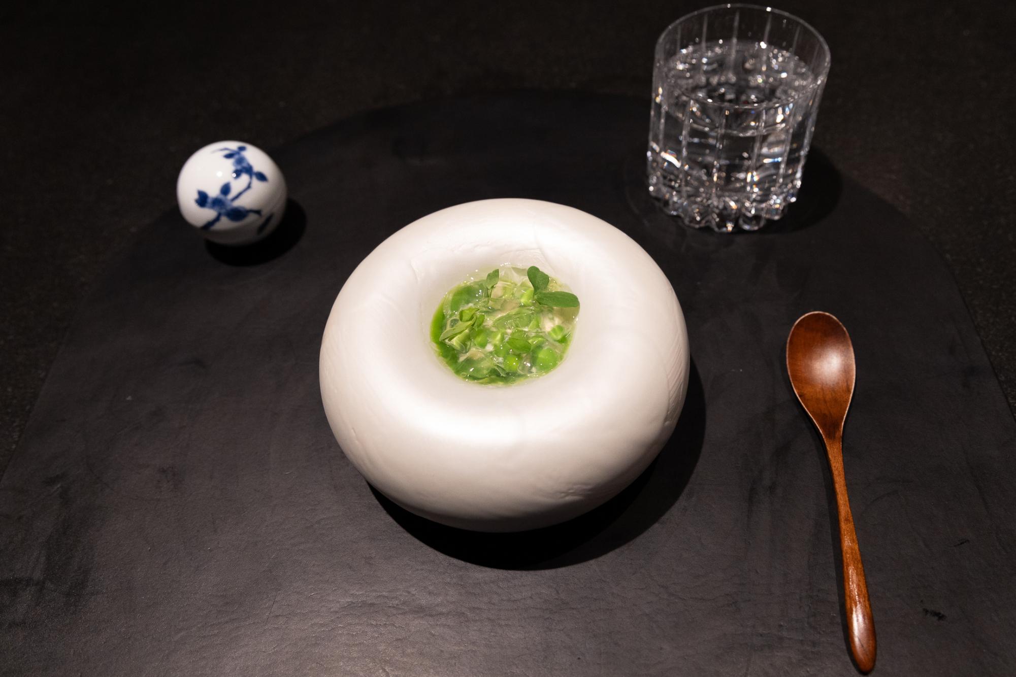 A white bowl with peas and jelly.