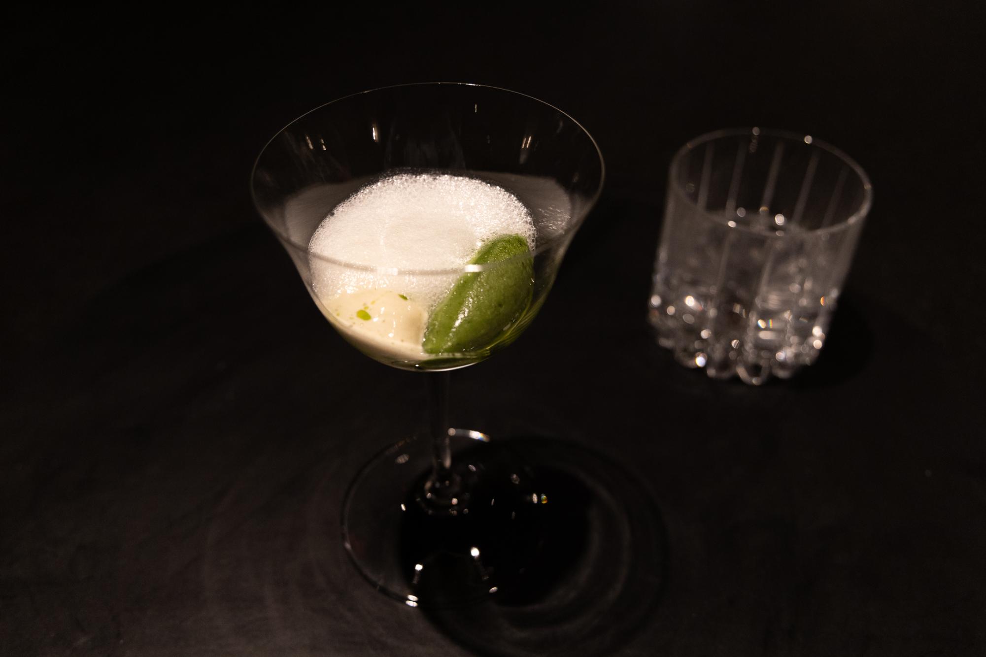 A glass with mint foam, ice cream and oil.
