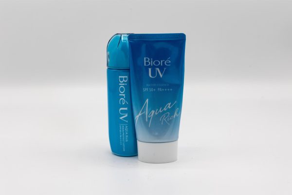 Two blue Biore sunscreen bottles. One bottle is a tube while the other is a stick.