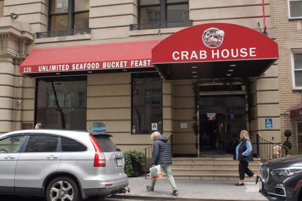 Front of a restaurant with a red awning that says “UNLIMITED SEAFOOD BUCKET FEAST CRAB HOUSE.”