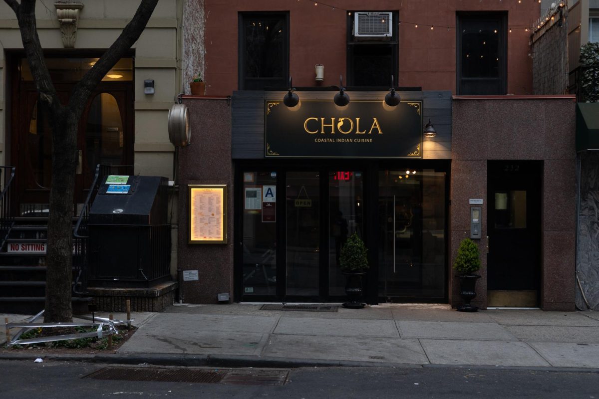 The exterior of a restaurant with a sign saying “CHOLA” and, below that, “COASTAL INDIAN CUISINE."