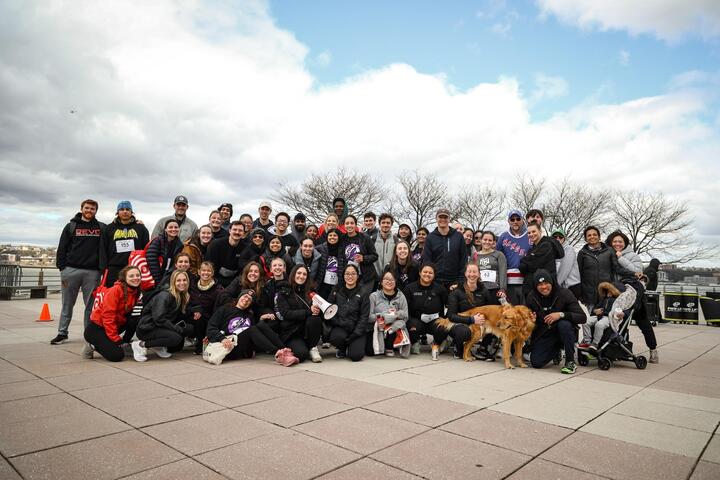 Participants smile in a team photo with a dog.