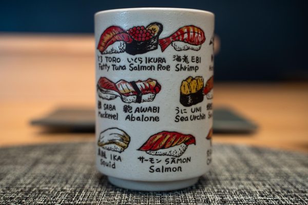A white cup with illustrations of sushi and their names.