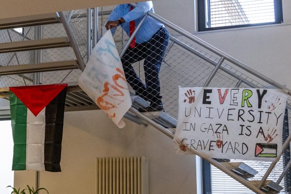 A person taking down a poster that was on a staircase.